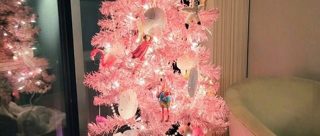 Kiddo laying in front of a beautiful pink Christmas tree.