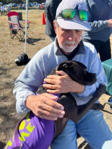 Rey hugging Bill sitting on a chair at Phillippi Farmhouse Market.