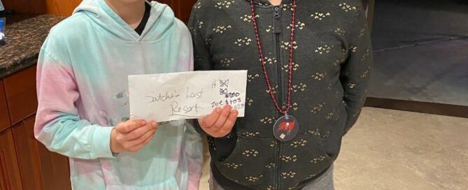 Audrey and Zoe smiling holding the envelope of money.