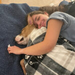 Jimbo snuggling on the couch with one of his new sisters.