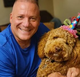 Mike and Nellie (in a birthday hat) smiling at the camera.