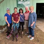 START volunteers with Michal Anne, Gail and Rey (dog) under the Satchel's sign.