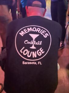 A Memories Lounge customers wearing a Memories Lounge t-shirt - back view.