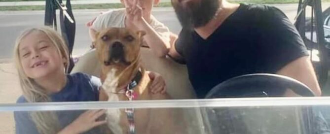 Bailey in a golf cart with his new dad and 2 siblings.