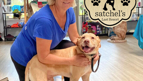 Bernie standing with Gail in a pet store. Bernie standing smiling, Gail on one knee.