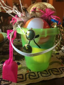 A pail full of goodies - glasses, hat, ball - for the party.