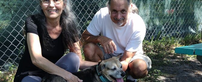 Dakota wih her new mom and dad in the yard at Satchel's, sitting at the picnic table.