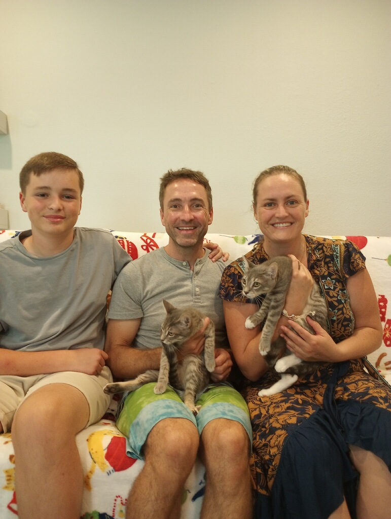 Rabbit and Roo in the arms of family all sitting on the couch