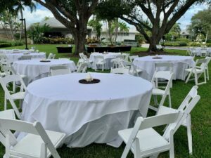 Pciture of the tables set outside under the oaks (last year)