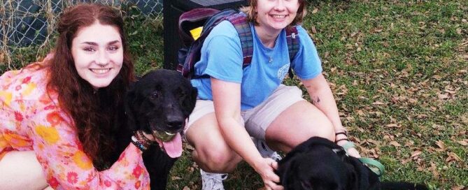 Salem and Kai sitting with their new moms, in the yard at Satchel's.