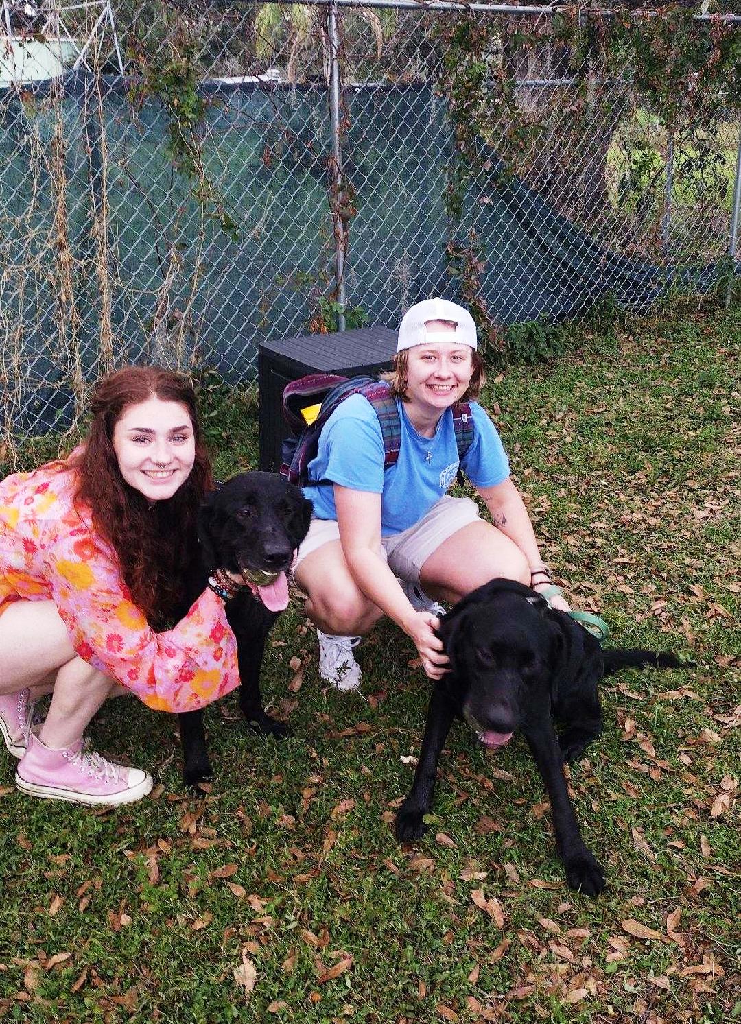 Salem and Kai sitting with their new moms, in the yard at Satchel's.