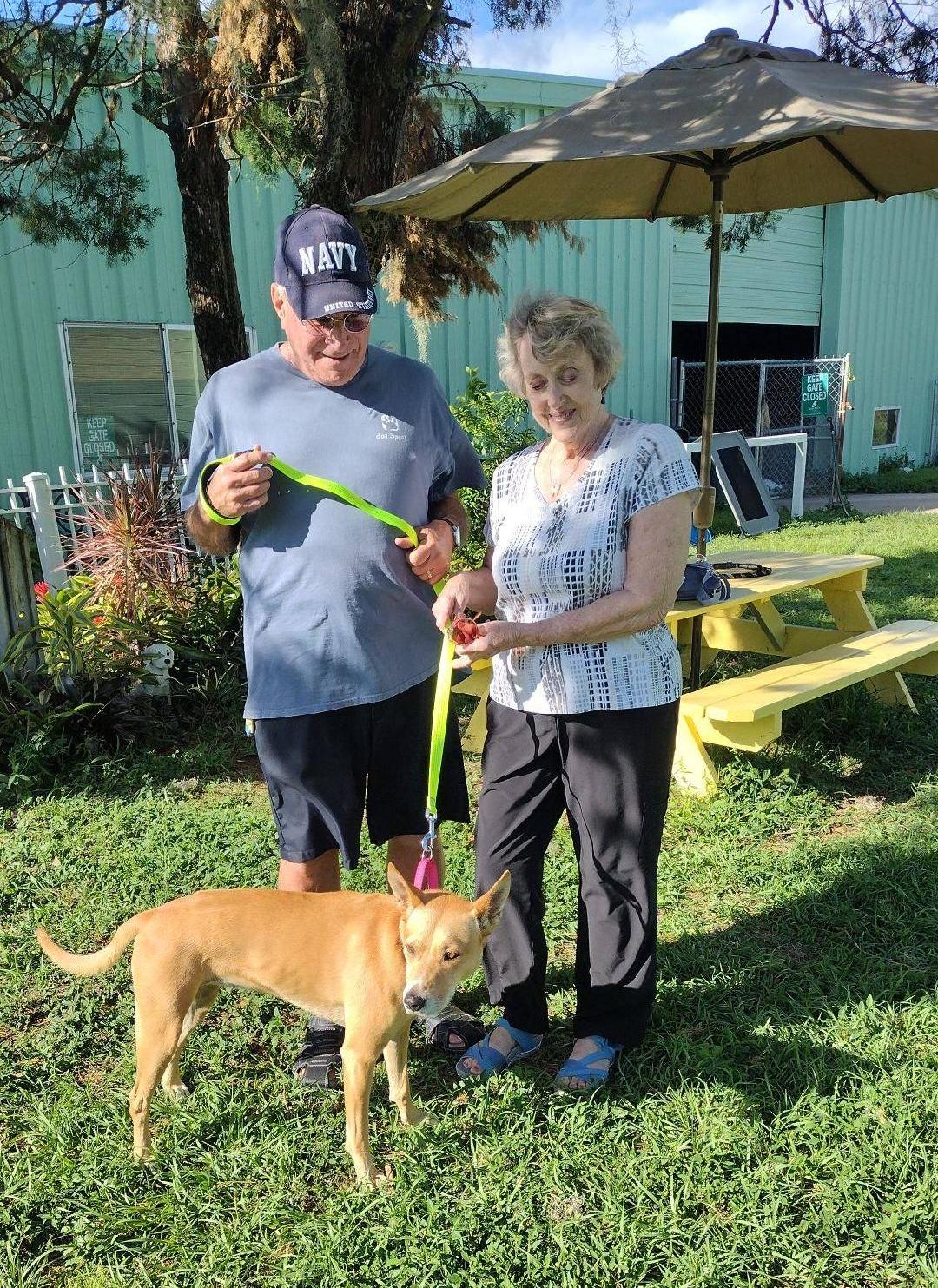 Meribel standing with her new mom and dad in the yard at Satchel's.