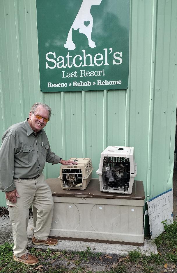 Milo and Zuma in crates with dad standing beside.