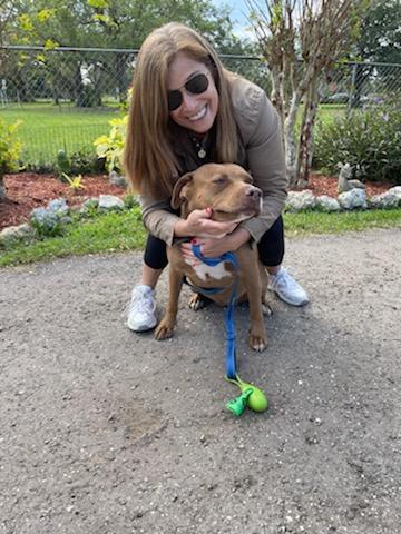 Sheri (adopter) bending over hugging Nakoma at Satchel's.