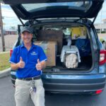 Subaru employee loading the vehicle with donations.