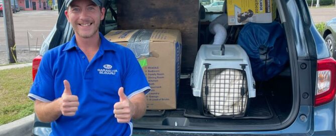 Subaru employee loading the vehicle with donations.