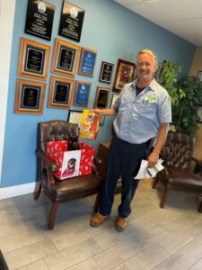 Donation box in the lobby at Cool Today with Joseph standing beside.