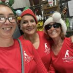 Lacie, Amelia and Pam our decorators in their red shirts ready to hang stockings.