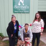 Tax Collector staff at Satchel's with Michal Anne, Director of Operations, and ZigZag with donations behind.