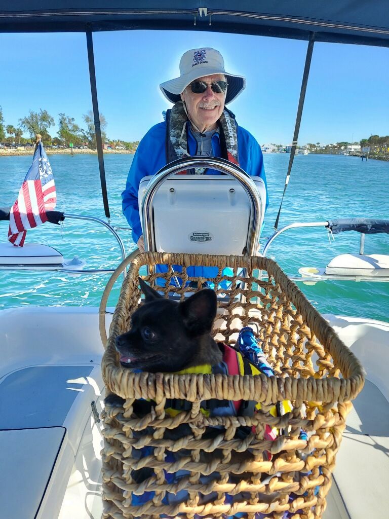 Creo in a basket in the boat. Roy at the helm.