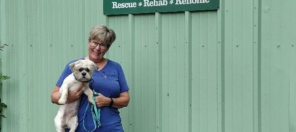 Dumpling being held by his new mom in the courtyard at Satchel's.