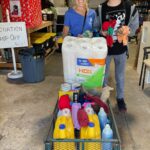 Ringling student and Page standing beside a cart full of donations at Satchel's.