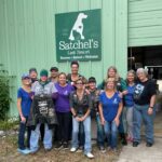 Skull Dogs and Satchel's volunteers under the Satchel's sign.