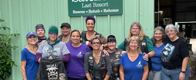 Skull Dogs and Satchel's volunteers under the Satchel's sign.