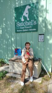Brutus sitting on his mom's lap outside Satchel's.