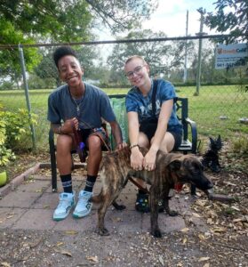 Dottie outside Satchel's with her new family sitting on the bench behind her.