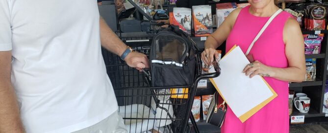 Mufasa in the carrier, new mom and dad standing beside.