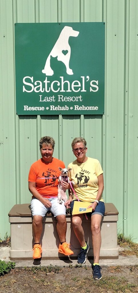 Dandy sitting on the laps of her new moms outside Satchel's.