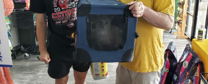 Petey and Petunia in a carrier with new family holding in Pet Supermarket.