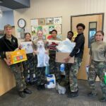 A few of the SMA students holding boxes of donations at the school.