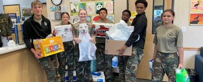 A few of the SMA students holding boxes of donations at the school.