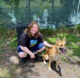 Ari sitting on the ground with her new mom outside Satchel's.