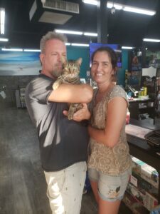 Jinx in the arms of his new mom and dad in the store.