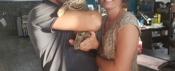 Jinx in the arms of his new mom and dad in the store.